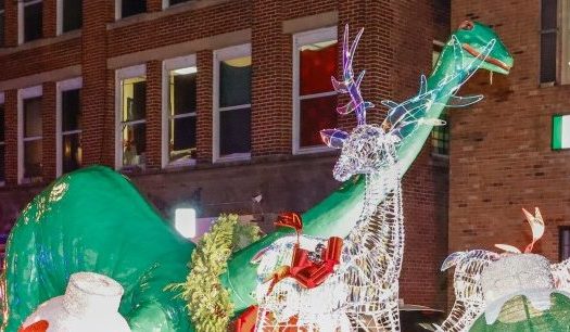 Poinsettia the Dinosaur, a lost tradition revived by Mayor Dean Mazzarella, arrives back into the Leominster community in front of Allen’s Dept. Store, located at 26 Main St., Friday evening. (GARY FOURNIER)