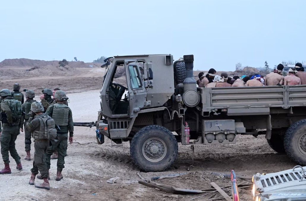 Israeli soldiers stand by a truck with Palestinian detainees in the Gaza Strip on Dec. 8. (Yossi Zeliger/Reuters)