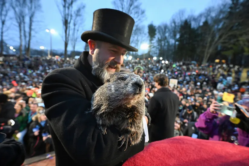 Groundhog Club handler A.J. Dereume holding Punxsutawney Phil, the famed groundhog known for predicting the weather, during the 138th celebration of Groundhog Day on Gobbler's Knob in Punxsutawney, PA, on Friday, Feb. 2, 2024. According to Phil's handlers, he has indicated an early arrival of spring this year. (Barry Reeger/AP)