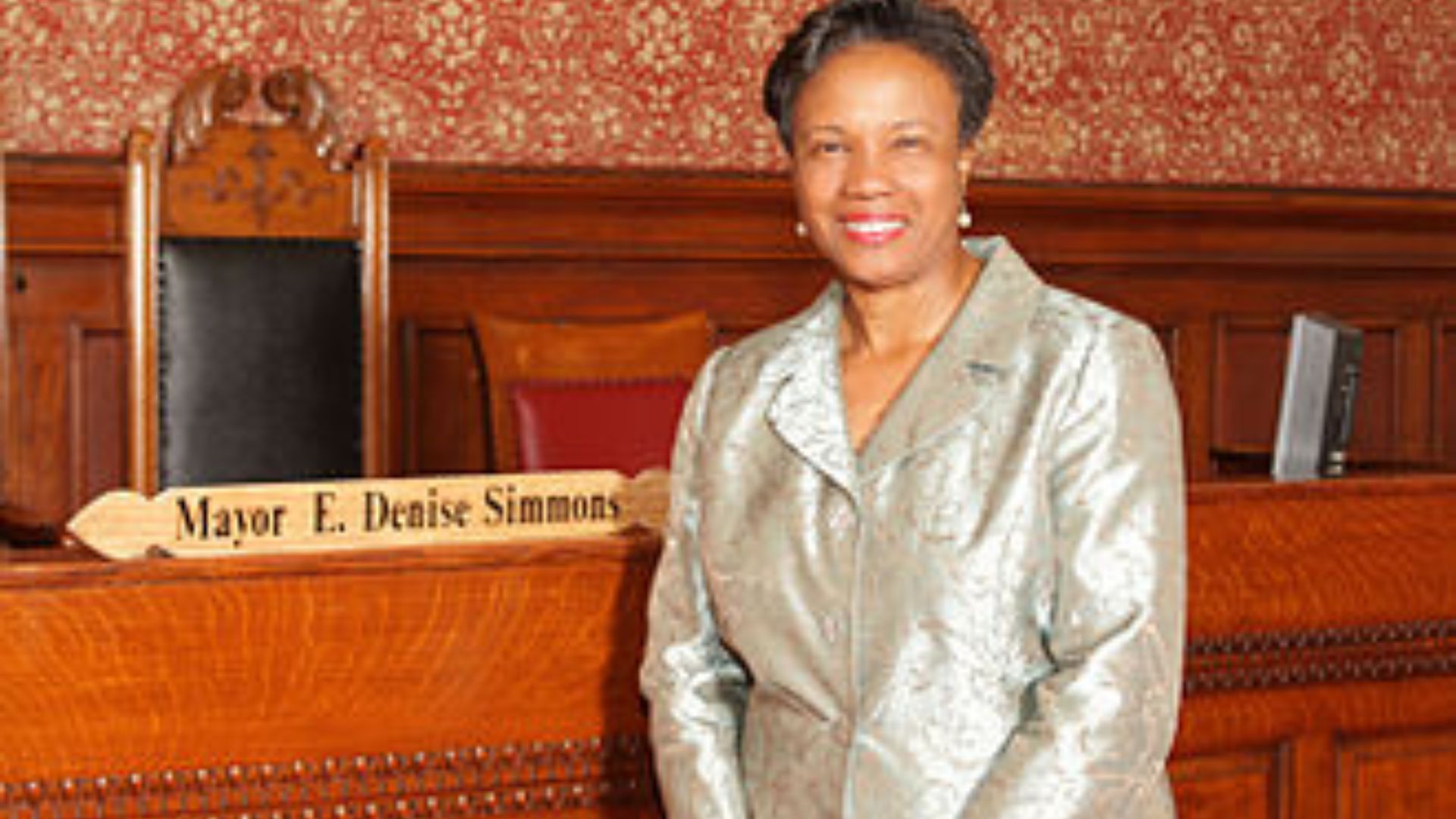 Cambridge Massachusetts' Mayor E. Denise Simmons standing in front of a placard with her name on it in city hall. (Photo Courtesy of Wikipedia)