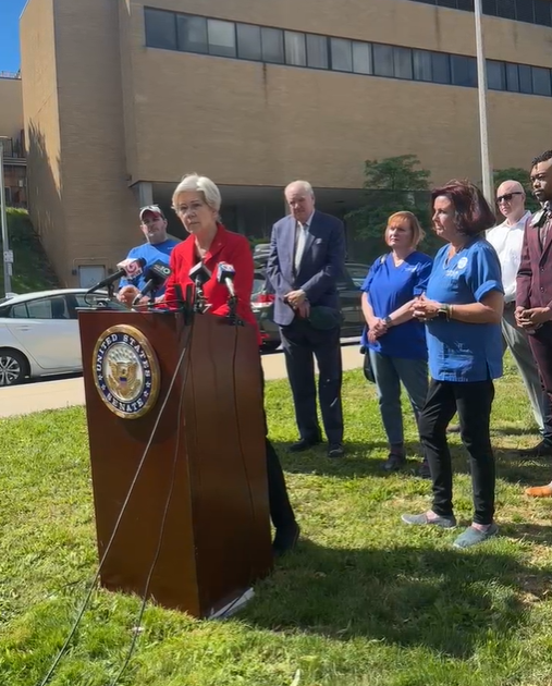 Elizabeth Warren standing at a podium outside of St. Elizabeth's Medical Center in Brighton, Massachusetts. (Photo: Facebook)