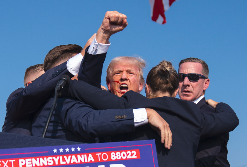 Trump with blood on face surrounded by Secret Service at campaign rally after he was nearly assassinated last night.