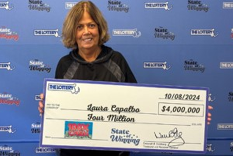 Laura Capalbo poses with her oversized winnings check at the Mass Lottery headquarters. (Photo Credit: MassLottery.com)