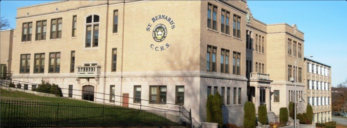 Exterior view of St. Bernard's High School, a multi-story, traditional brick and stone building with large windows, located at 45 Harvard Street. The school's name and initials, 'C.C.H.S.', are prominently displayed on a circular crest on the front of the building.