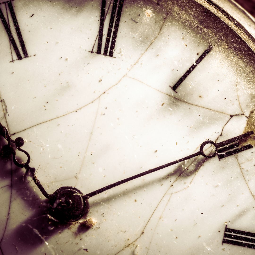 A close-up of an old, cracked clock face with Roman numerals, symbolizing the passage of time and the upcoming daylight saving time change.