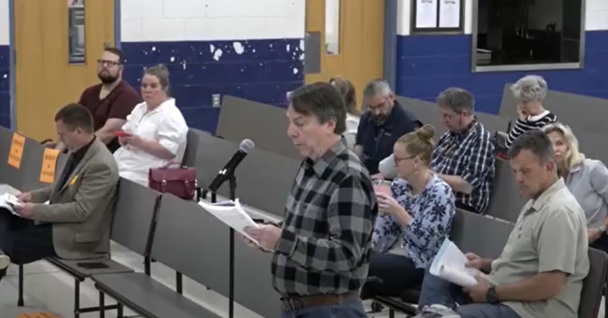 Derek Nurr speaks at a microphone during the May 3, 2025, Westminster Town Meeting, advocating for paving Leino Park Road.
