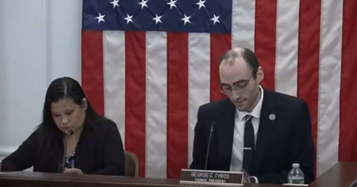 Council President George C. Tyros speaks into a microphone during the Gardner Informal City Council Meeting on June 2, 2025, seated in front of an American flag.